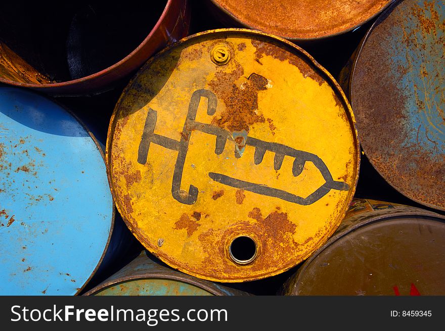 The end of an old oil drum, stacked up with others, waiting to be used as a waste bin at a music festival. This bin for used syringes. The end of an old oil drum, stacked up with others, waiting to be used as a waste bin at a music festival. This bin for used syringes.