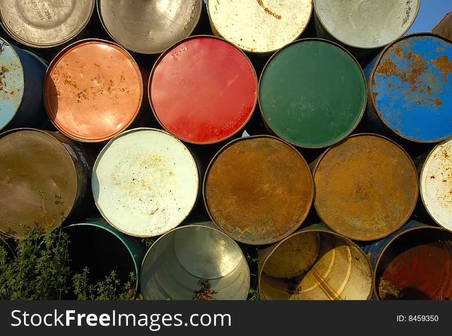 A stack of grungy old oil drums at a music festival, ready to be set out as rubbish bins. A stack of grungy old oil drums at a music festival, ready to be set out as rubbish bins.