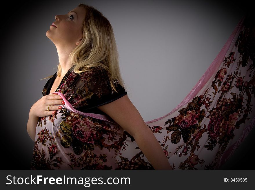 Side view of pregnant woman wearing stole on an isolated background