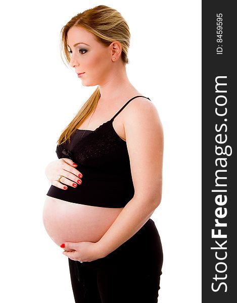 Side view of pregnant female keeping hands on her tummy on an isolated background