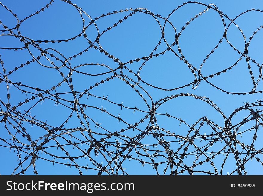 Barbed wire over blue sky