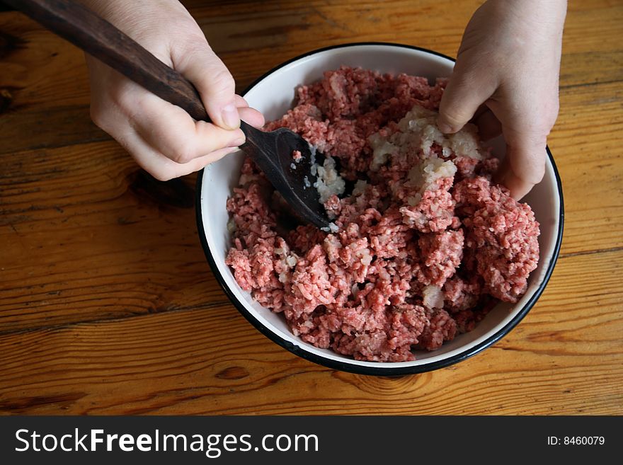 Women mixing raw mincemeat for raviolli. Women mixing raw mincemeat for raviolli