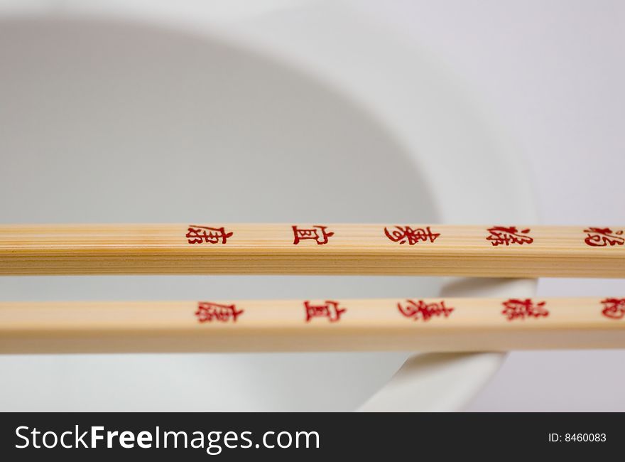 Chopsticks with Chinese or Japanese writing on a bowl , a detail