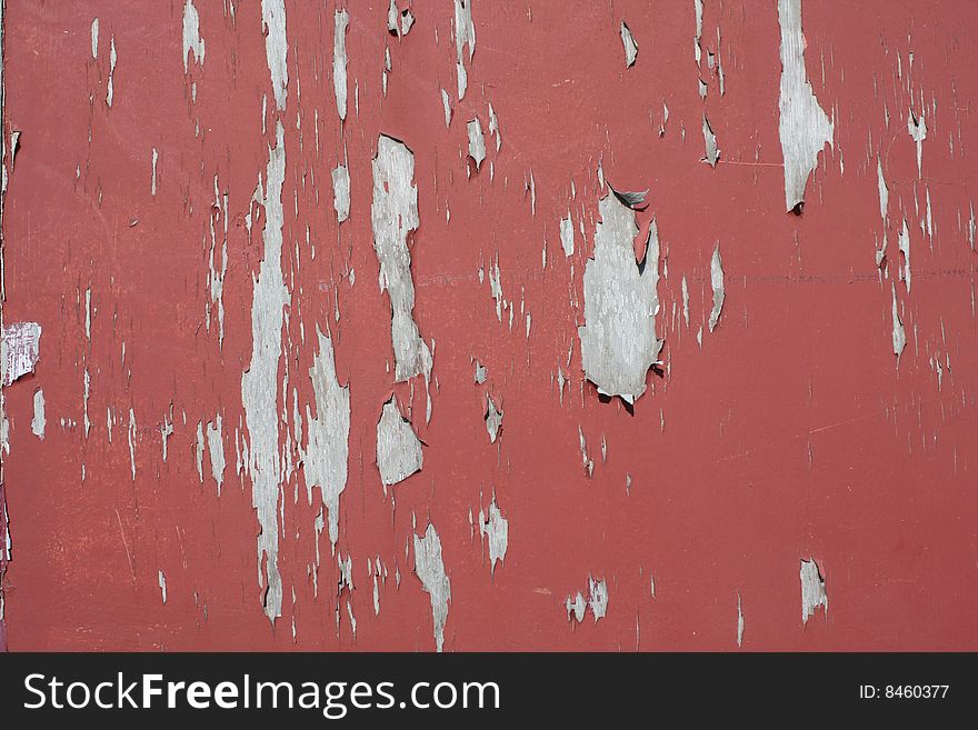 Cracked and peeling red paint on a wooden surface creating an interesting background. Cracked and peeling red paint on a wooden surface creating an interesting background.