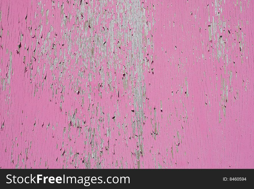 Cracked and peeling pink paint on a wooden surface creating an interesting abstract background. Cracked and peeling pink paint on a wooden surface creating an interesting abstract background.