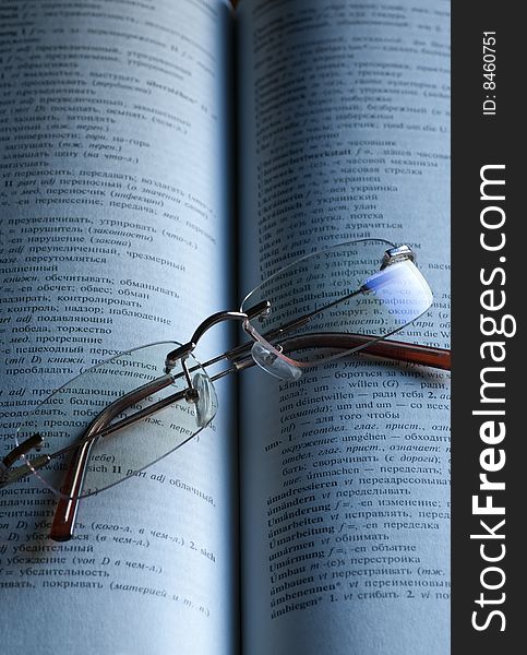A pair of reading glasses on an open book