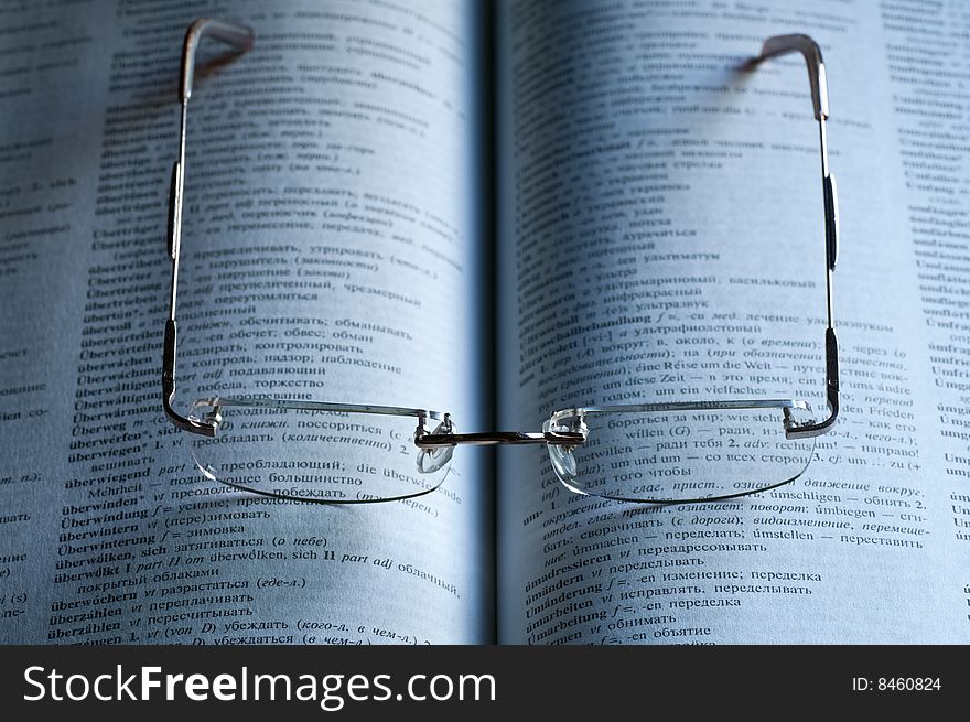 A pair of reading glasses on an open book