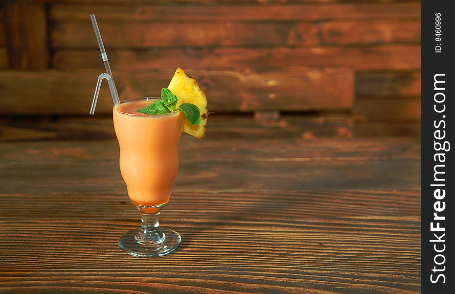 Cocktail smoothie with pineapple and mint on a wooden rack