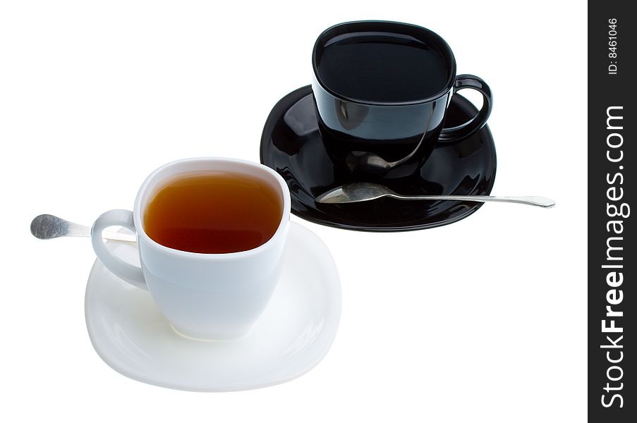 White and black cups with tea, isolated