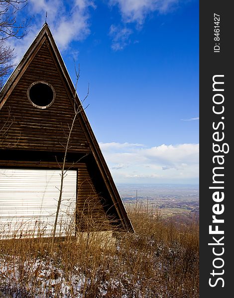 Log cabin in mountains during winter day