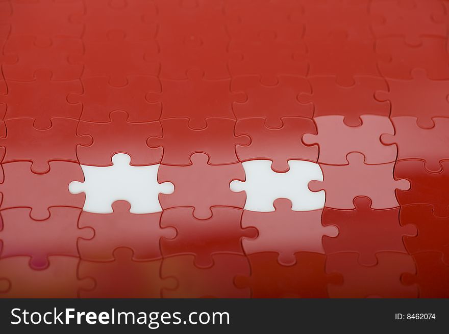 Red plastic puzzle with two white pieces. Red plastic puzzle with two white pieces