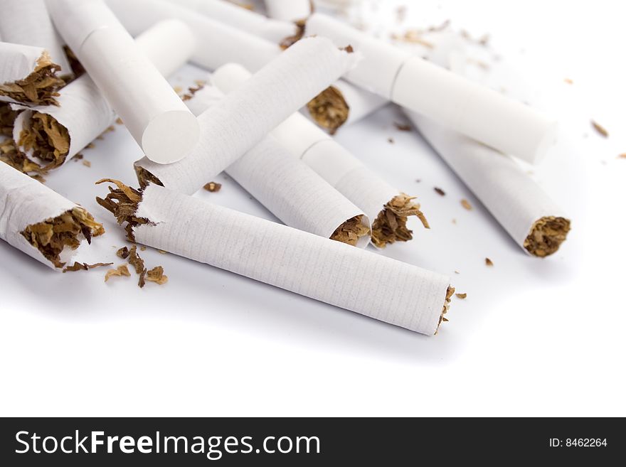 Broken cigarettes closeup on white background