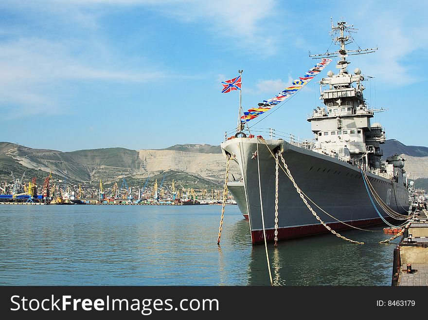 A battleship anchored in the harbour. The water is still