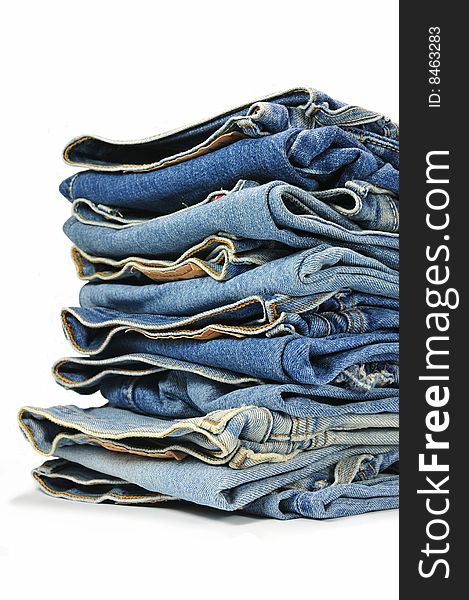 Big bunch of washed-out blue jeans isolated on white background