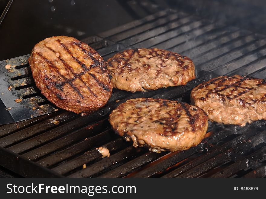 Flipping a buger on a barbeque with a spatula. Flipping a buger on a barbeque with a spatula.