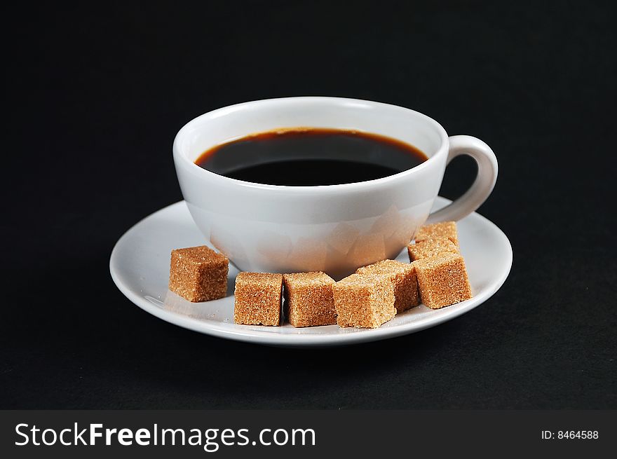 White cup of black coffee with sugar cubes