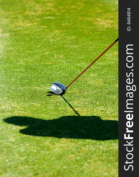 An image of a golfer's shadow while preparing to put