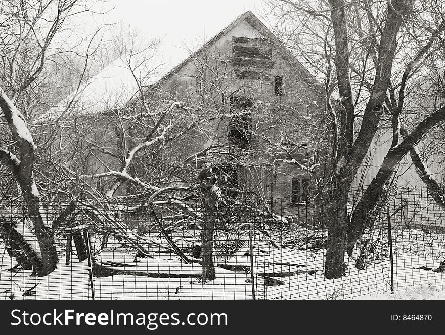 Black & white photo of an old farm house buried in the woods. snow, winter. Black & white photo of an old farm house buried in the woods. snow, winter