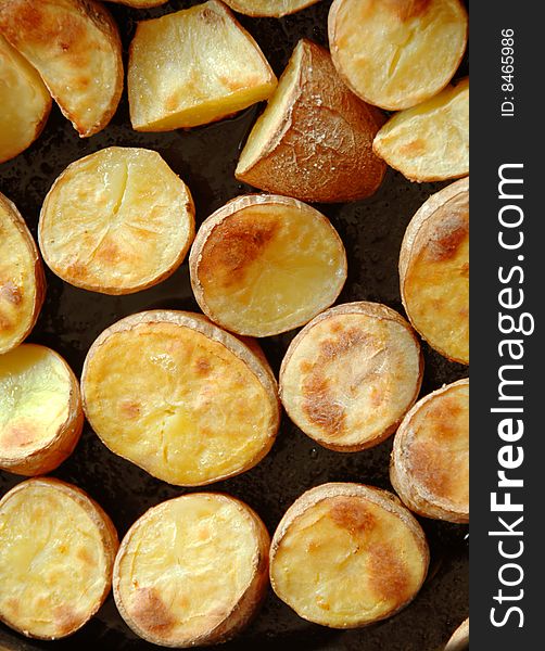 Baked brown potato pieces on black background. Baked brown potato pieces on black background
