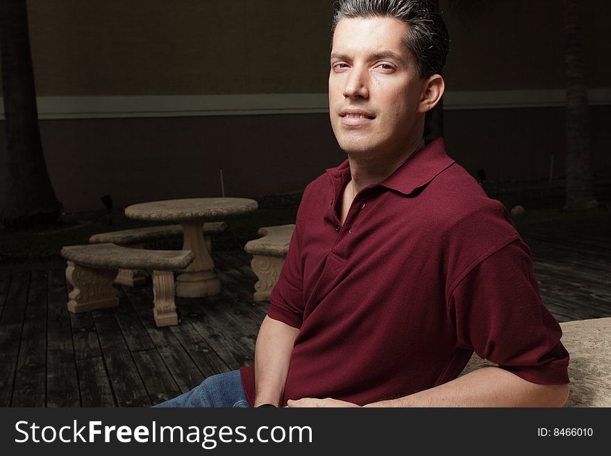 Handsome young businessman sitting at a park table. Handsome young businessman sitting at a park table