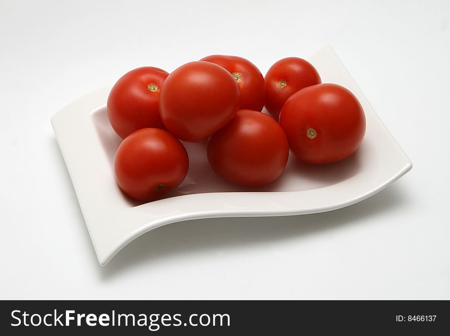 Couple of tomatoes on saucer isolated on white background
