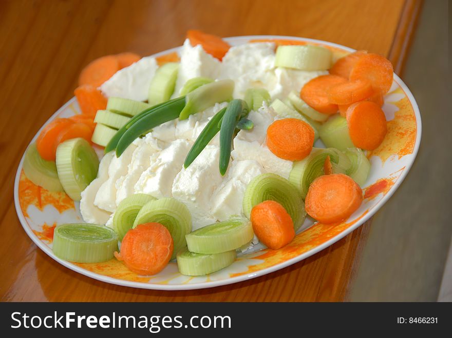 Cut green leek, carrot and white cheese slices closeup. Cut green leek, carrot and white cheese slices closeup