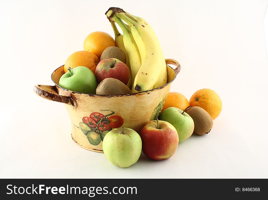 A basket filled with delicious fresh fruits with some in front of it. A basket filled with delicious fresh fruits with some in front of it