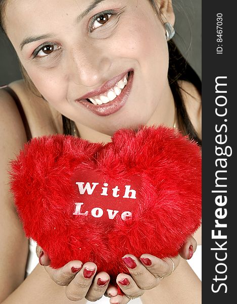 Indian girl model holding a red heart. Indian girl model holding a red heart.