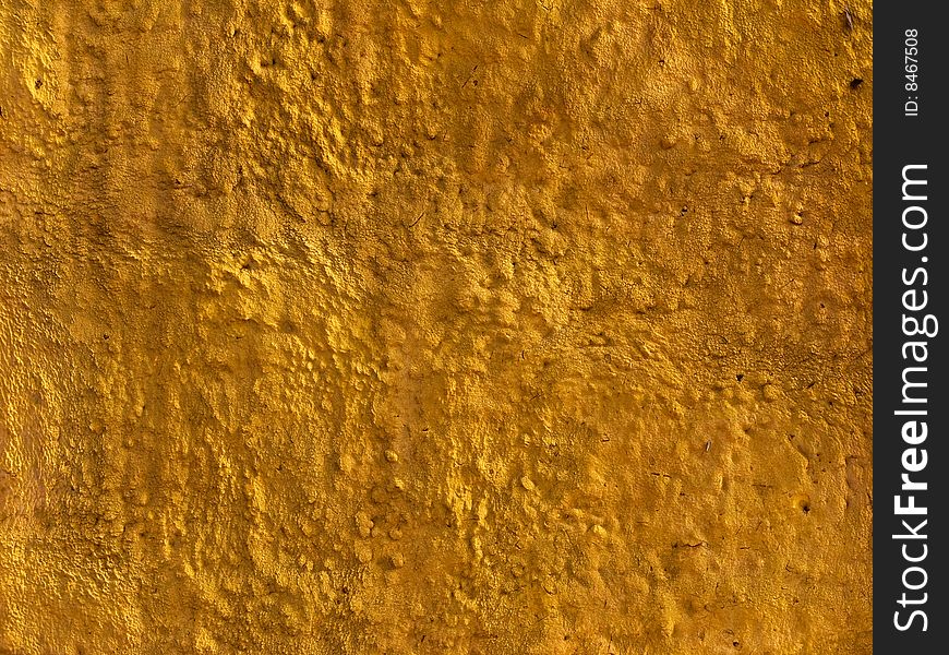 Fragment of yellow concrete wall protective covering surface. Fragment of yellow concrete wall protective covering surface