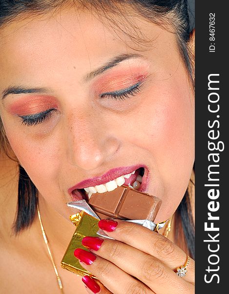 Indian girl eating chocolate bar