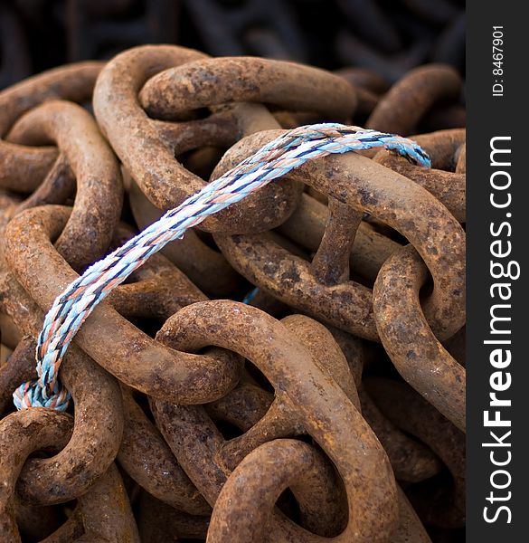 Large rusty chains held together by thin pieces of string. Business metaphor for control. Large rusty chains held together by thin pieces of string. Business metaphor for control