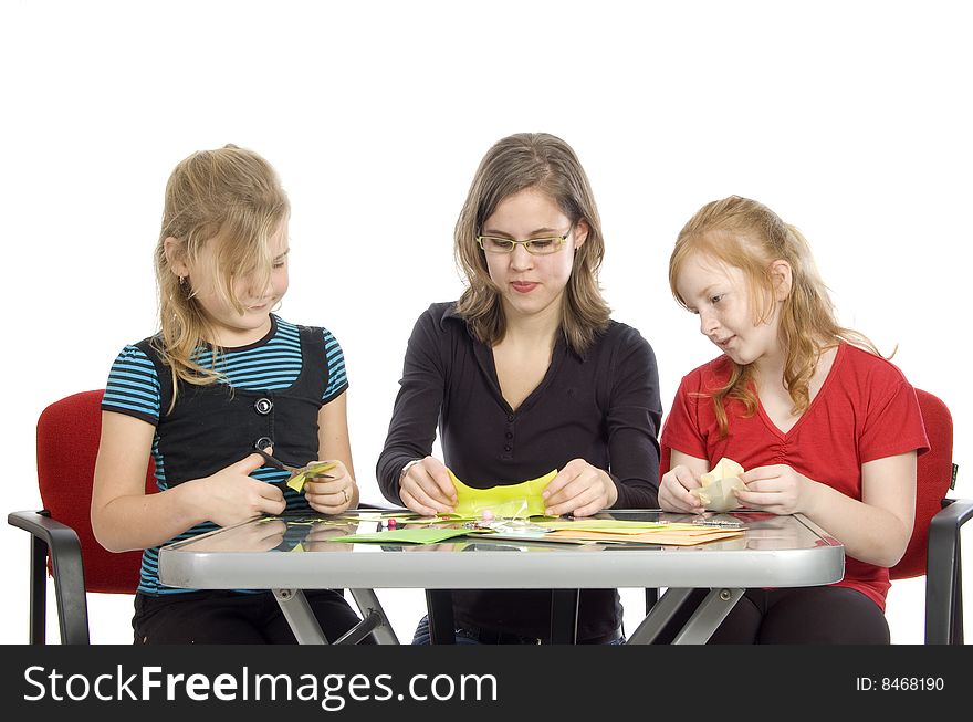 Teacher is showing two little girls how to diy on white