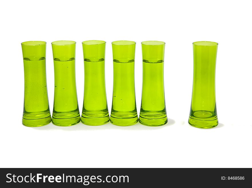 Group of glasses with one apart of them. Isolated on white. One of the possible concepts behind it is that: the group of glasses is a team and the standing alone one is the leader.