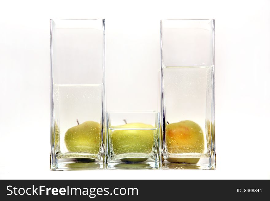 Glass transparent vases and green apples