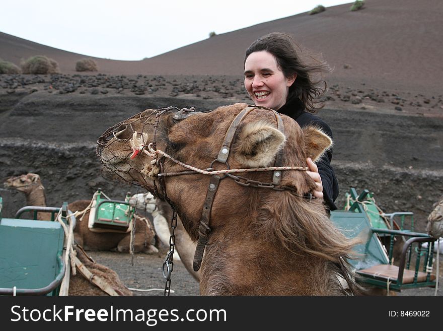 Tourist camel with a woman petting the head