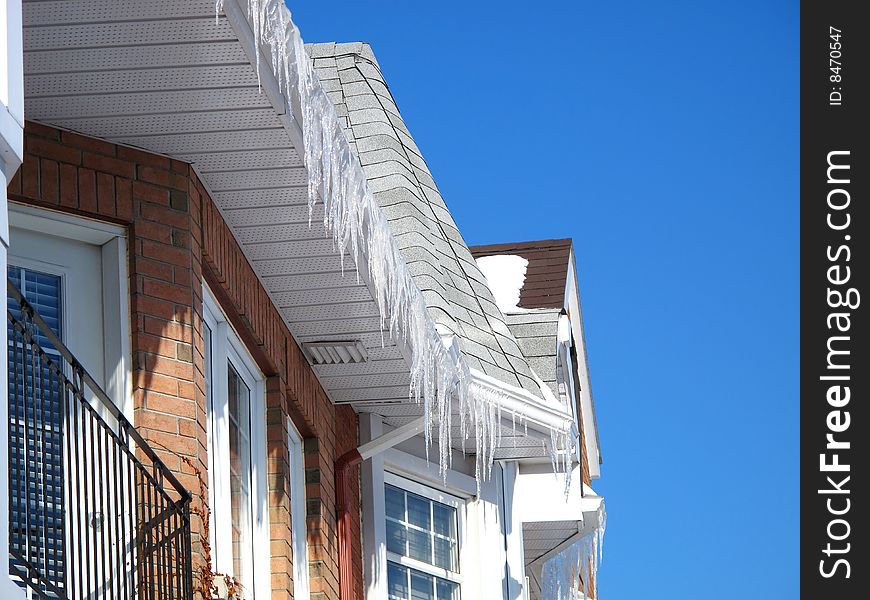 Town homes with icicles and a blue sky