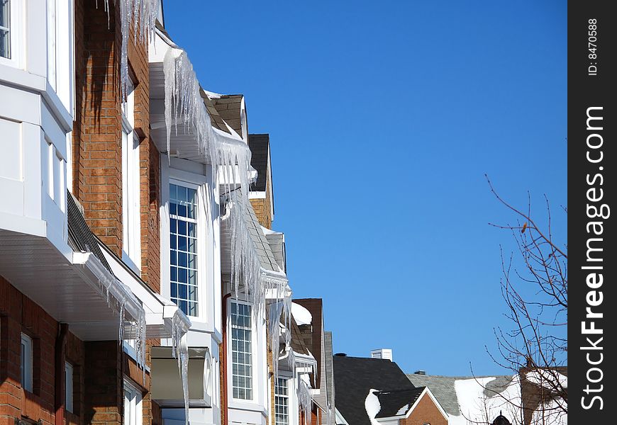 Town homes with icicles and a blue sky