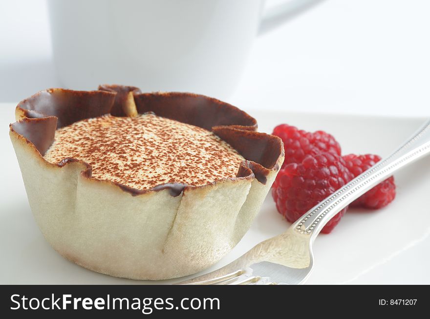 Tiramisu in a tart shell served with raspberries. Tiramisu in a tart shell served with raspberries.