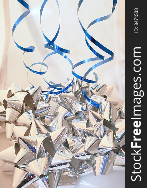 A grouping of silver bows and blue ribbons. A grouping of silver bows and blue ribbons.