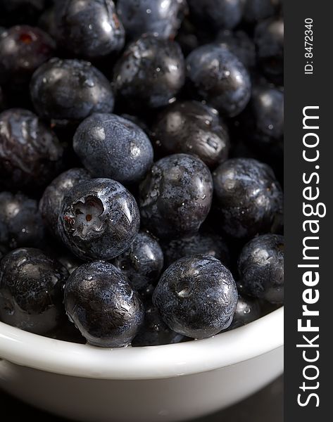 Freshly washed blueberries photographed in closeup in a white bowl. Freshly washed blueberries photographed in closeup in a white bowl.