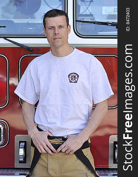 A fireman stands in front of fire truck. A fireman stands in front of fire truck