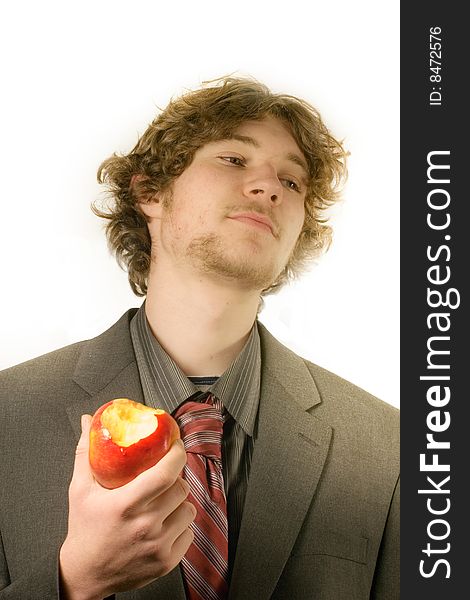 Young man in a business suit eating a red apple. Young man in a business suit eating a red apple