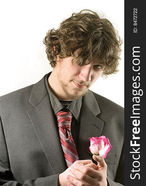 Young man in a romantic mood with a rose  in his hands, isolated on white. Young man in a romantic mood with a rose  in his hands, isolated on white