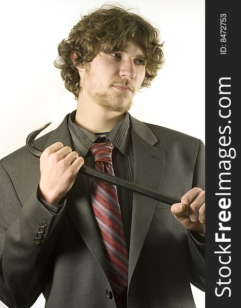 Young man in a business suit, holding a crowbar, either breaking something, or defending himself. Young man in a business suit, holding a crowbar, either breaking something, or defending himself.