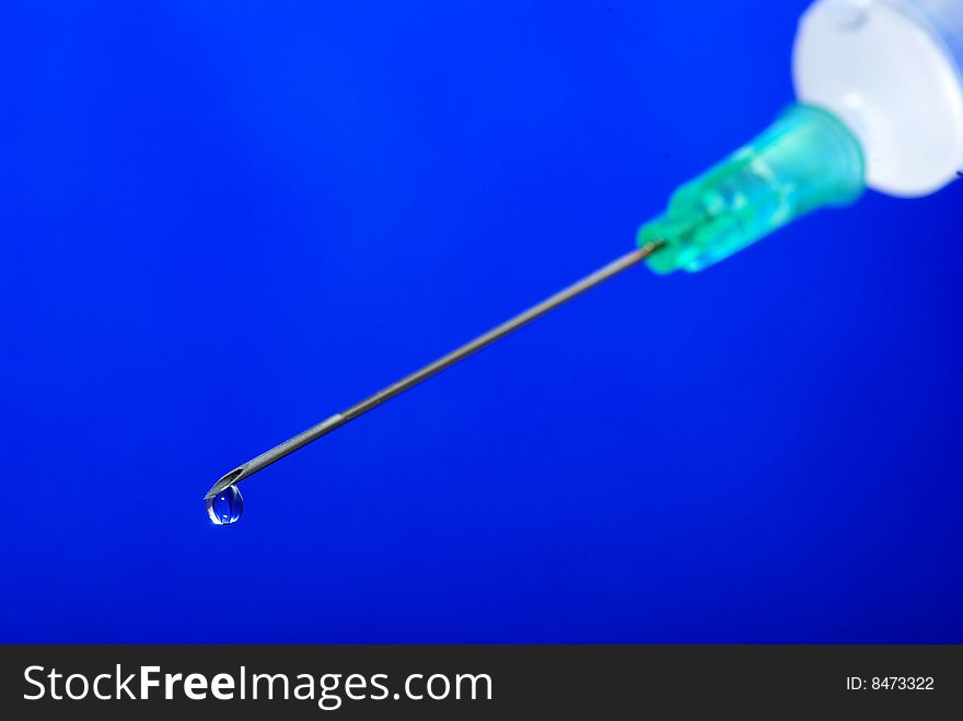 Drop on syringe needle macro on blue