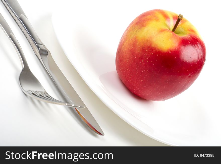 Close-up photo of utensils and red apple