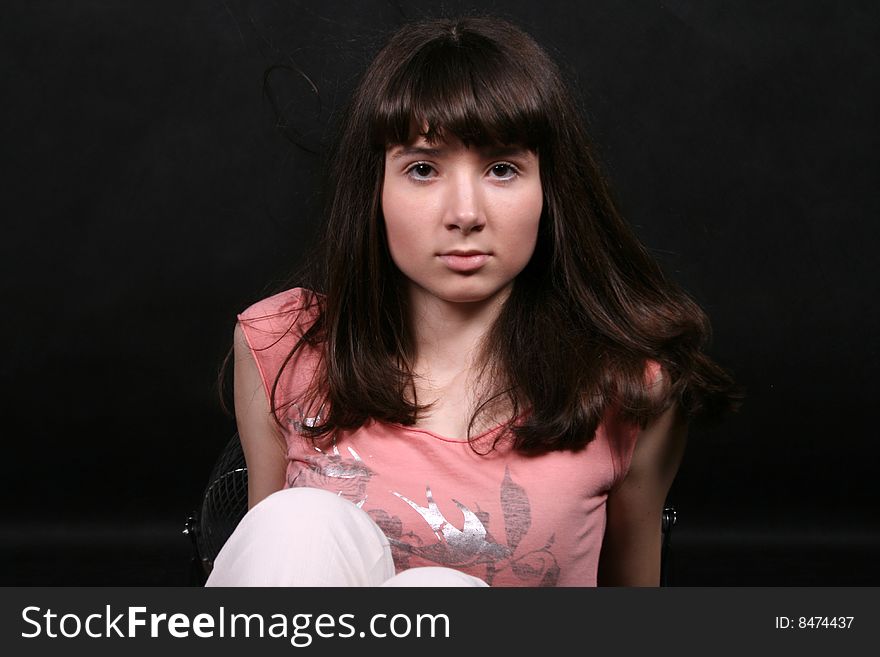 Girl with waving hair sitting in studio