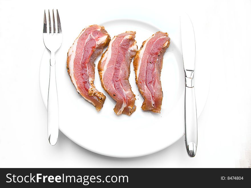 Fresh Bacon Slices Laying On White Plate