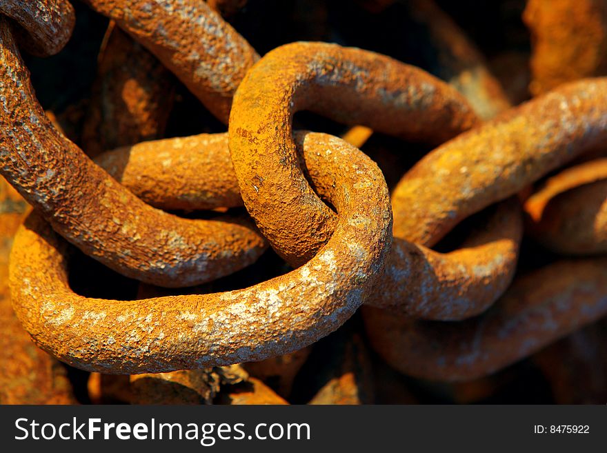 Old industrial chain links in at a fishing harbour. Old industrial chain links in at a fishing harbour