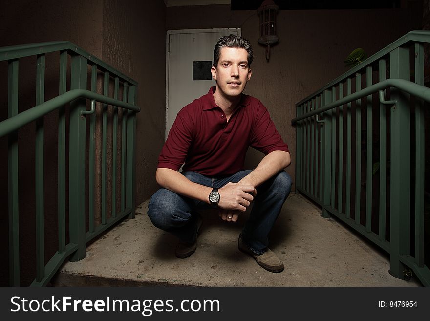 Man squatting on a staircase